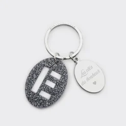 Porte-clés personnalisé médaille gravée ovale acier et breloque initiale acrylique pailleté bleu nuit