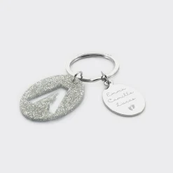 Porte-clés personnalisé médaille gravée ovale acier et breloque initiale acrylique pailleté argenté